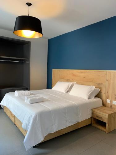 een slaapkamer met een groot bed met een blauwe muur bij Village Point Apartments in Sliema
