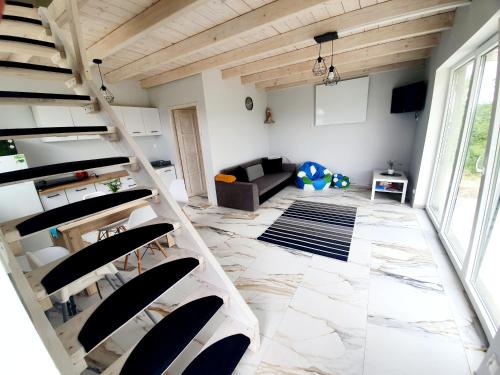 a living room with a staircase in a house at Domek Jozef z prywatnym duzym Jacuzzi i sauna Przystan pod niebem in Leczyce