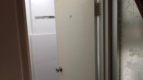 a bathroom with a white door and a shower at Apartemen Cibubur village by ipol in Cibubur