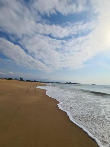 a beach with the ocean and a cloudy sky at Casa de Praia em Unamar Cabo Frio 6 pessoas in Cabo Frio