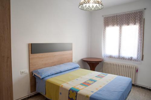 1 dormitorio con cama y lámpara de araña en Ca l'Armengol, en Balaguer