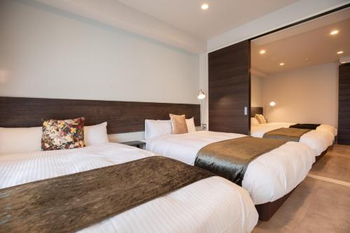 a row of beds in a hotel room at HOTEL so SUMIYOSHI in Fukuoka