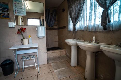 La salle de bains est pourvue de 2 lavabos et d'un miroir. dans l'établissement Cadeau Hiking and Accommodation, à Witelsbos