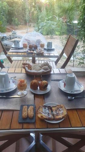 a table topped with plates of food and pastries at Chambre d'hôtes à 5mn des plages in Patrimonio