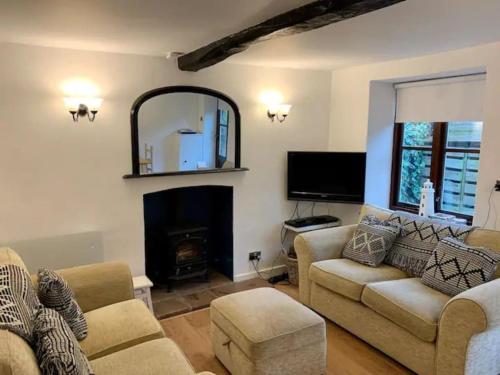 a living room with a couch and a fireplace at Haven Cottage, Golden Square in Cromer