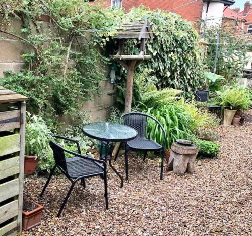 a table and chairs sitting in a garden at Haven Cottage, Golden Square in Cromer