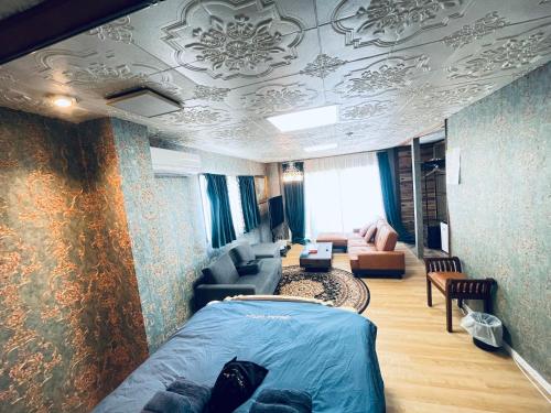 a bedroom with a bed and a living room at Ryokan La Luna in Ukusu