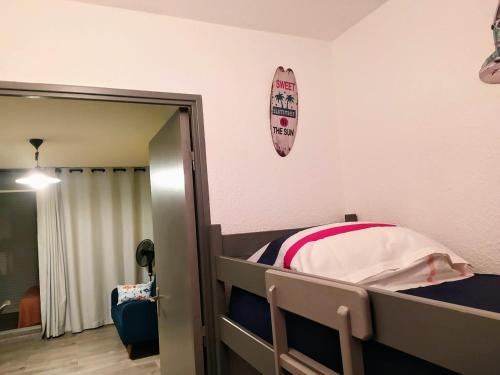 - une chambre avec des lits superposés et un miroir dans l'établissement ALAMANDA STUDIO LE GRAU DU ROI -, au Grau-du-Roi