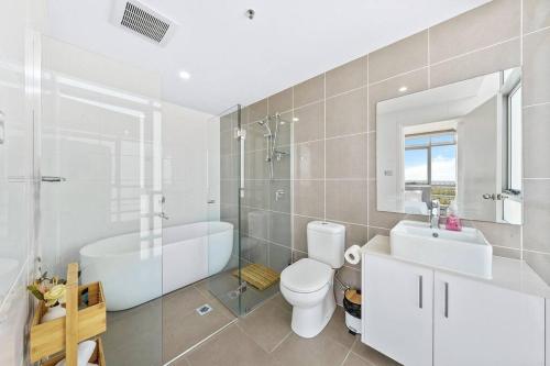 a bathroom with a tub and a toilet and a sink at Iconic Sydney Harbour Bridge view in Sydney