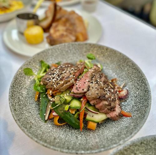 a plate of food with meat and vegetables on a table at Montigo Resorts, Somerset in Shepton Mallet