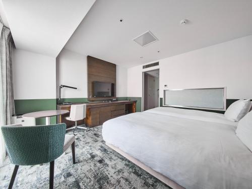 福山的住宿－福山站前里士滿酒店，一间卧室配有一张床、一张书桌和一台电视。