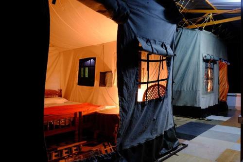 a room with a tent with a bed in it at The Forest Resort - Muneeswaramudi Eco Hermitage and Farms in Tindummal