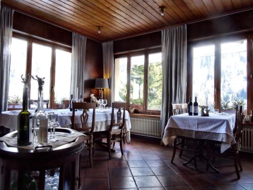 a dining room with two tables and windows at ECONOMY b&b in Bedretto
