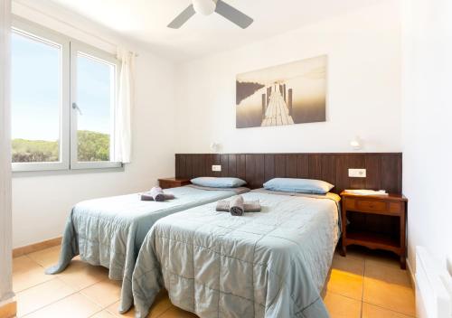a bedroom with two beds and two windows at Apartamento a 100 m de playa. Calella Palafrugell in Calella de Palafrugell