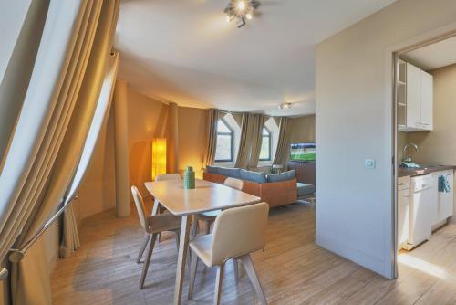 a dining room and kitchen with a table and chairs at Le Côté Vert in Waterloo