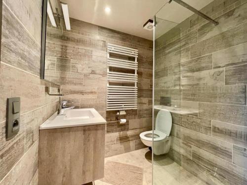 uma casa de banho com um WC, um lavatório e um espelho. em Aqua City Suite by Malmedreams em Malmedy