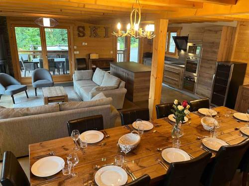 une salle à manger avec une table et un salon dans l'établissement Chalet Balata - Charming chalet with hot tub and views, à La Côte dʼArbroz