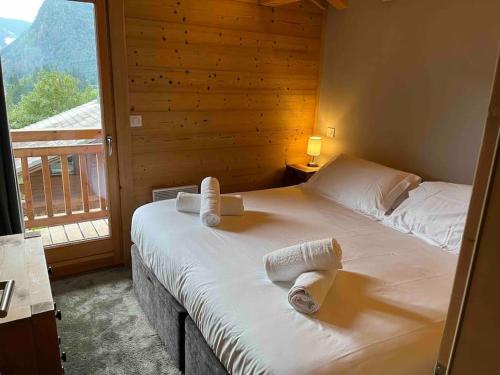 ein Schlafzimmer mit einem Bett mit Handtüchern darauf in der Unterkunft Chalet Balata - Charming chalet with hot tub and views in La Côte dʼArbroz