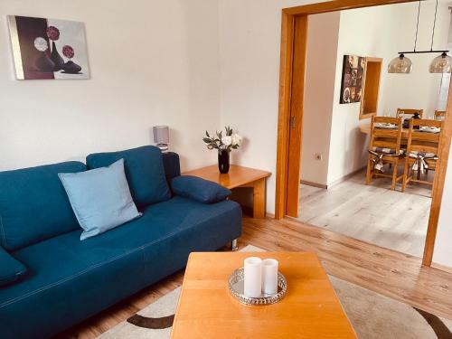 sala de estar con sofá azul y mesa en Ferienwohnung mit Garten - a88519 en Feistritz im Rosental