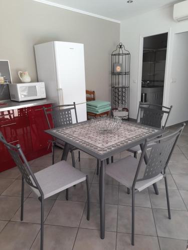 tavolo e sedie in cucina con frigorifero di Villa le Bosquet en Luberon. a Ménerbes