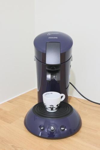 a coffee maker with a cup on a table at Le Cocon, Paisible & Doux in Wahlbach