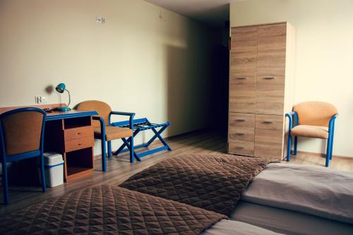 een slaapkamer met een bed, een bureau en stoelen bij Winnica Dwie Granice Agroturystyka Przysieki 