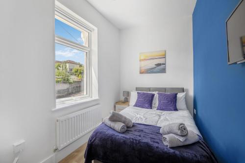 Un dormitorio con una cama con sábanas moradas y una ventana en Great Location Free Parking Near Tamar Bridge en Saltash