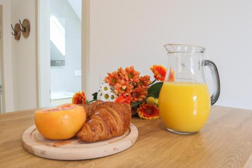 a table with a plate of food and a glass of orange juice at Le Cocon, Paisible & Doux in Wahlbach