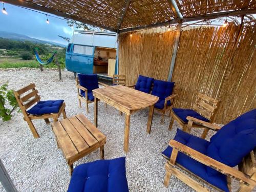 un patio con mesa de madera y sillas en Batroun van camping, en Batroun