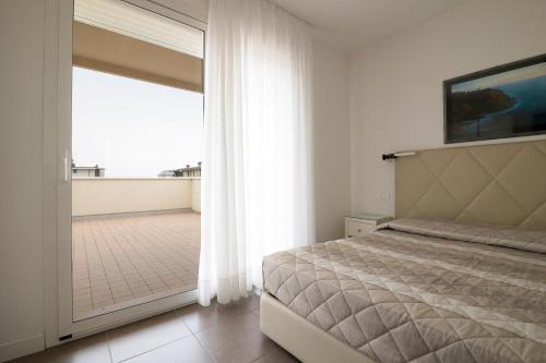 sypialnia z łóżkiem i dużym oknem w obiekcie Hotel Miami w mieście Lido di Jesolo