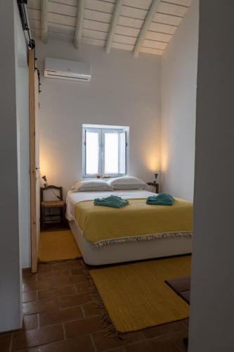 a bedroom with a bed and a window at Sunrise Monsaraz Green - 1km Castelo Monsaraz com telheiro e jardim in Monsaraz