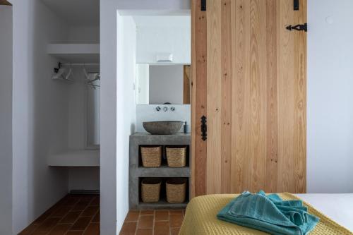 La salle de bains est pourvue d'un lavabo et d'un miroir. dans l'établissement Sunrise Monsaraz Green - 1km Castelo Monsaraz com telheiro e jardim, à Monsaraz