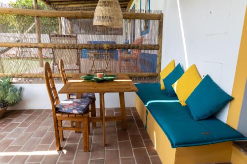 a room with a table and chairs on a balcony at Sunrise Monsaraz Green - 1km Castelo Monsaraz com telheiro e jardim in Monsaraz