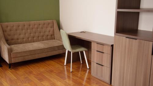 a desk with a chair next to a wooden cabinet at People Guest House in Bishkek