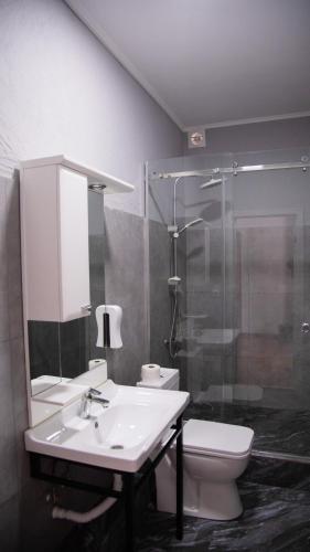 a bathroom with a sink and a toilet and a shower at People Guest House in Bishkek