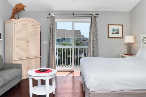 a white bedroom with a bed and a balcony at Barrier Dunes 426 - 62 Beach House Too by Pristine Properties Vacation Rentals in Oak Grove