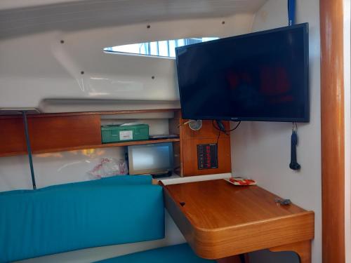 ein Wohnzimmer mit einem Tisch und einem Flachbild-TV in der Unterkunft Jeanneau Sun Way 25 in Hrdoňov