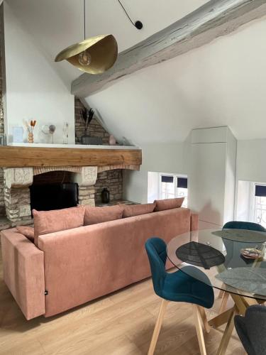 ein Wohnzimmer mit einem Sofa und einem Tisch in der Unterkunft Clos Théodore - Appartement climatisé avec sauna, petite terrasse et mezzanine in Givry