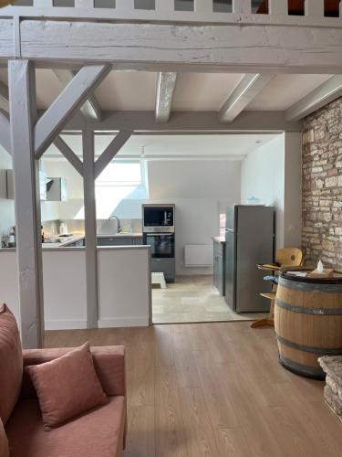 ein Wohnzimmer mit einem Sofa und einer Küche in der Unterkunft Clos Théodore - Appartement climatisé avec sauna, petite terrasse et mezzanine in Givry