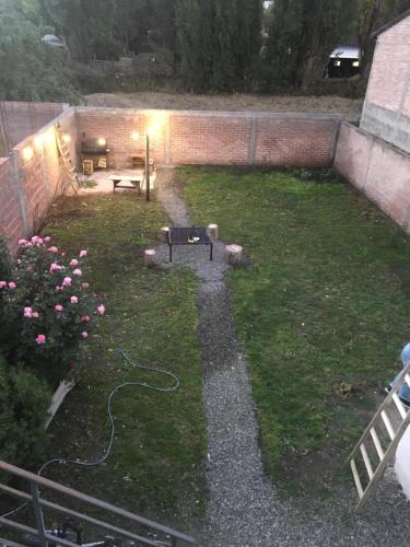 a backyard with a garden with a hose on the grass at Departamento en Junin de Los Andes in Junín de los Andes
