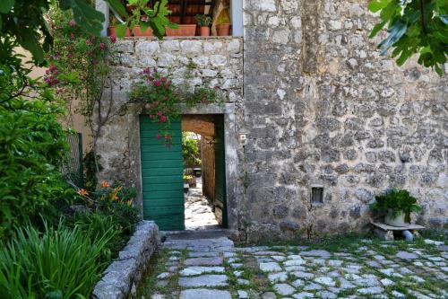 an entrance to a stone building with a green door at Apartments Subotic in Risan