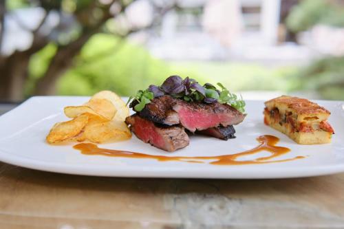 a plate of food with meat and chips on a table at Le Côté Vert in Waterloo