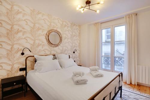 une chambre avec un lit avec deux serviettes dessus dans l'établissement Pick A Flat's Apartment in Montmartre - Rue Drevet, à Paris