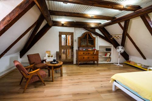 a attic bedroom with a bed and a table and chairs at Art House Radovljica in Radovljica