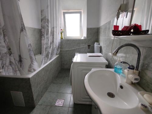uma casa de banho com um lavatório, uma banheira, um WC e um lavatório. em Edelweiss guesthouse, glamping and camping em Suhaia