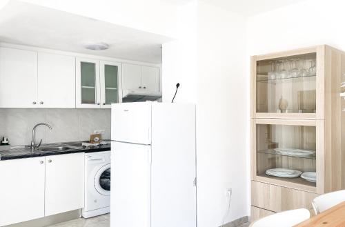 una cucina con mobili bianchi e un frigorifero bianco di Los Barqueros 24 by Best Holidays Fuerteventura a Corralejo