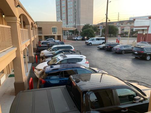 a row of parked cars parked in a parking lot at Americas Best Value Inn-Near NRG Park/Medical Center in Houston