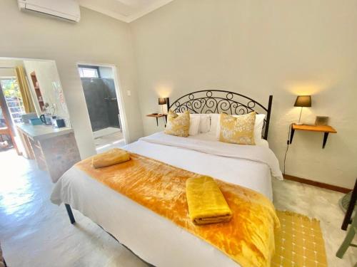 een slaapkamer met een groot bed met een gele deken erop bij Selah Guest Cottages Self-catering Farmstay Accommodation in Nelspruit