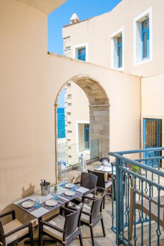 a patio with tables and chairs on a balcony at Captain's House Hotel Suites & Apartments in Panormos Rethymno