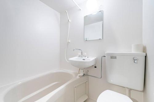 a white bathroom with a sink and a bath tub at 渋谷まで電車で1駅 2分池尻大橋駅まで徒歩8分民泊アパート in Tokyo